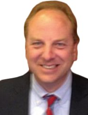 A man in a suit and tie is smiling for the camera.