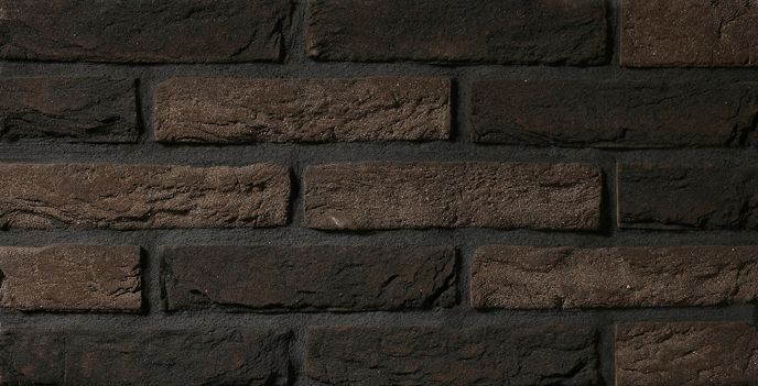 Ciemna ceglana ściana z zaprawą w różnych odcieniach brązu i czerni.