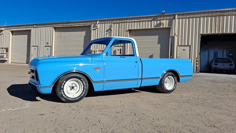 A blue truck is parked in front of a building