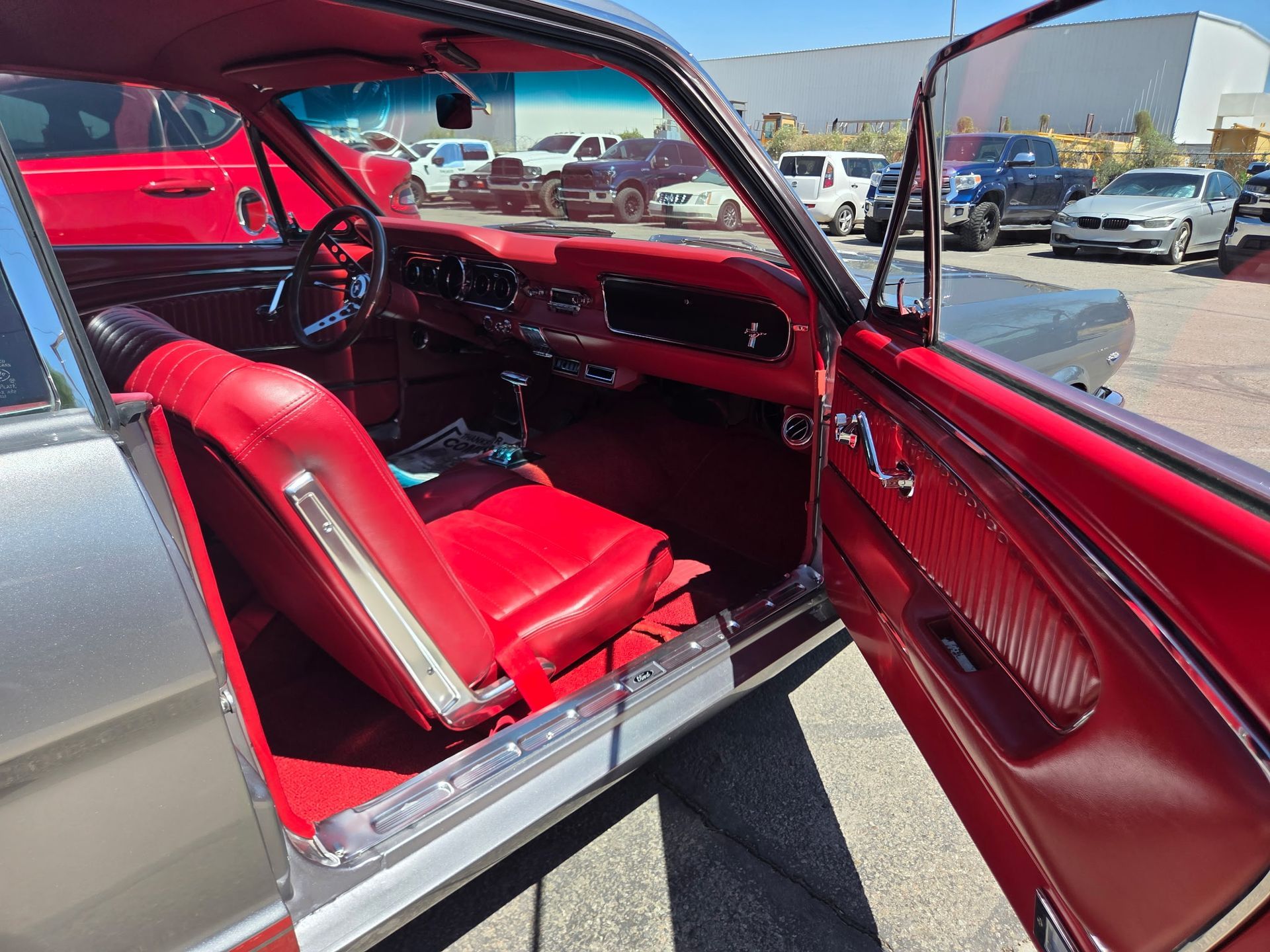 Red classic car interior with bright red seats and open door at a car show
