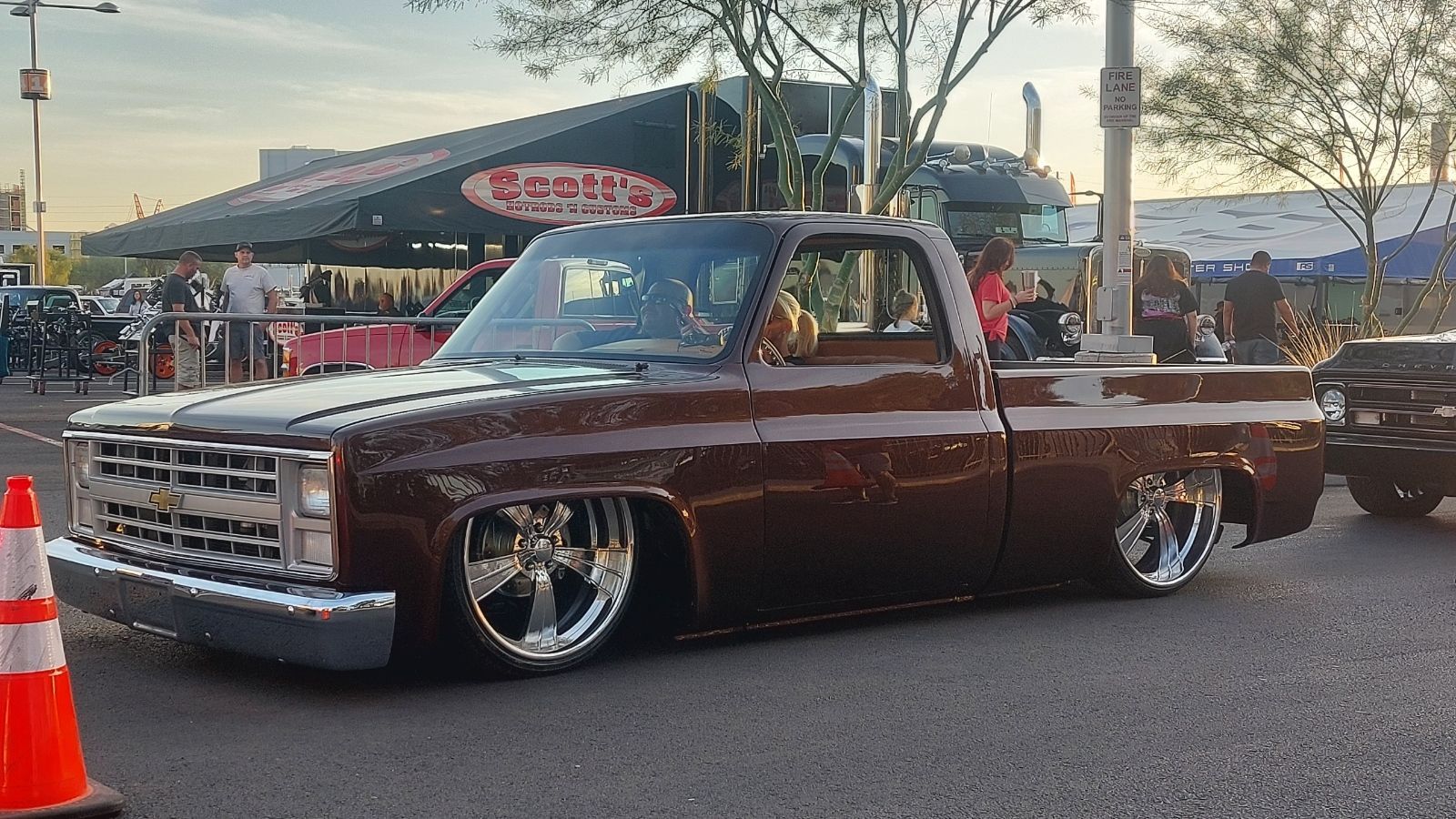 A brown truck is parked on the side of the road in front of a restaurant.