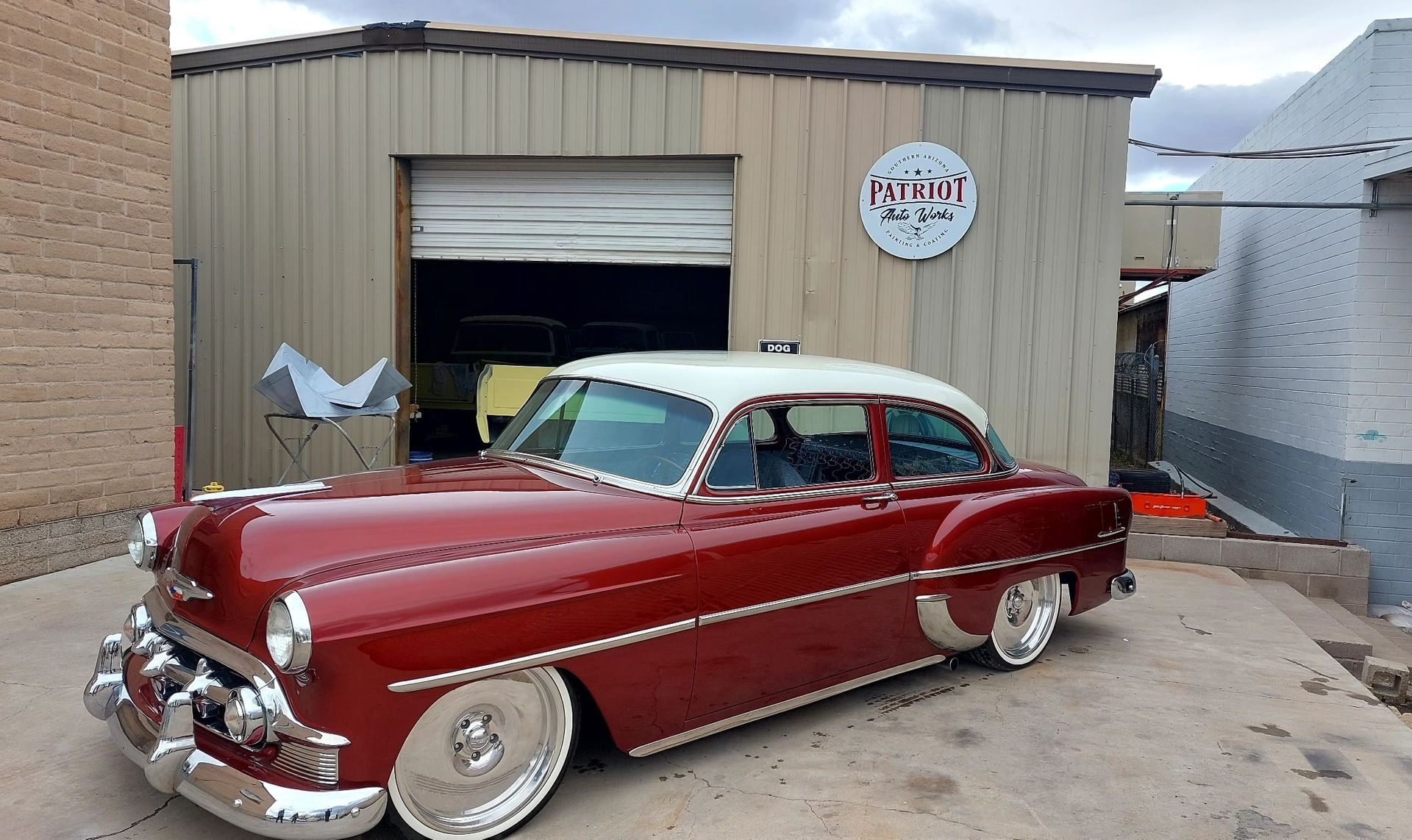 A red car is parked in front of a building with a sign that says pilot