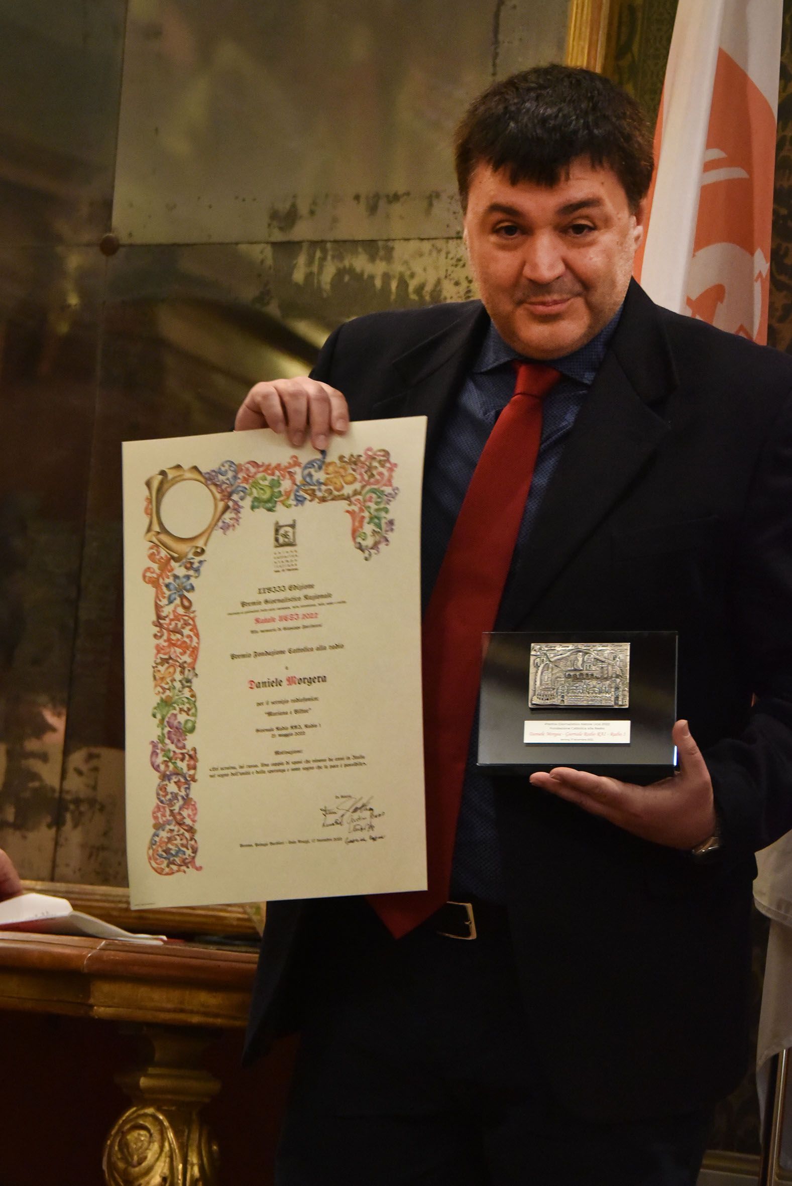 Un uomo in giacca e cravatta ha in mano un certificato