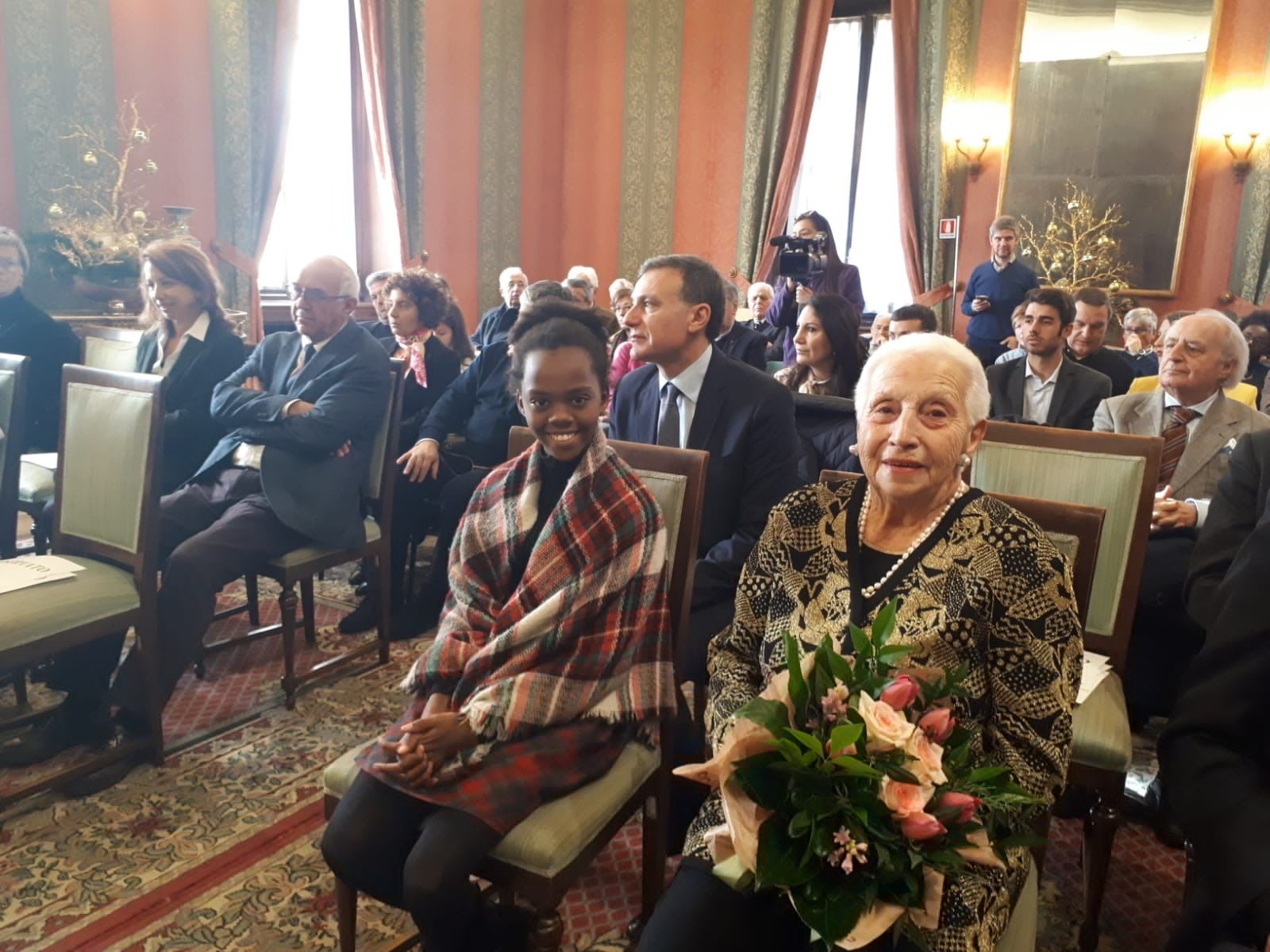 Un gruppo di persone è seduto sulle sedie in una stanza.