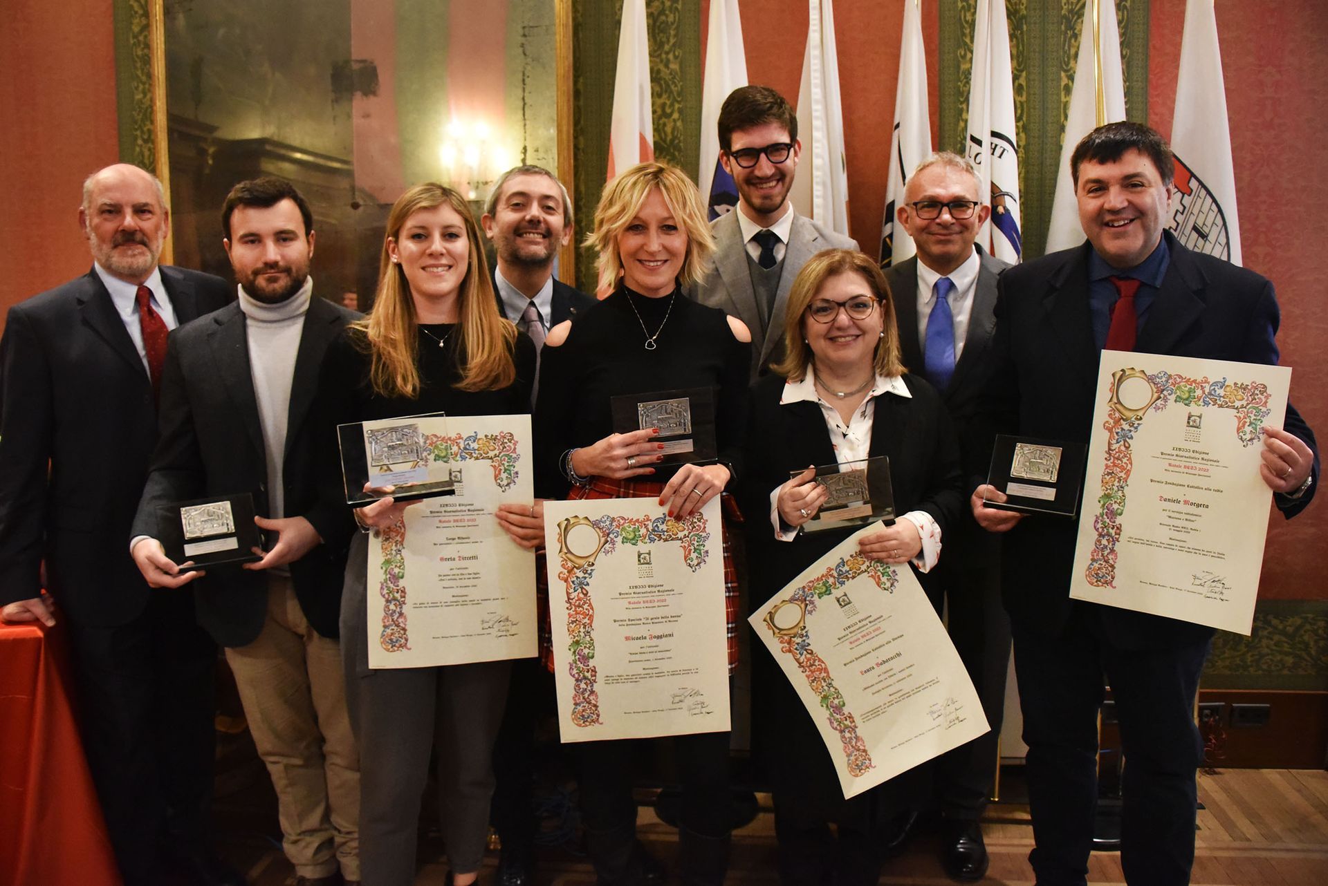 Un gruppo di persone sta posando per una foto mentre tiene dei premi.