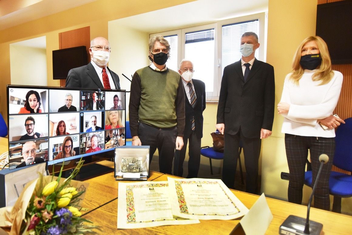 Un gruppo di persone che indossano maschere per il viso sono in piedi attorno a un tavolo.
