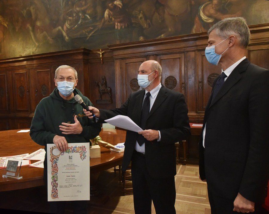 Tre uomini che indossano maschere per il viso sono in piedi uno accanto all'altro in una stanza.