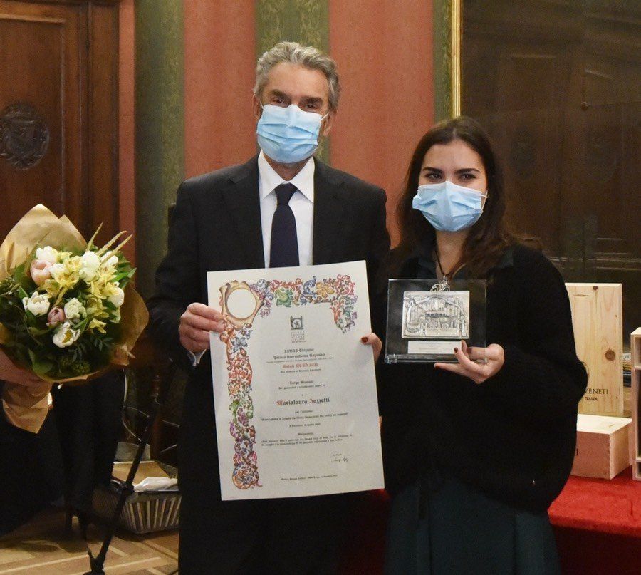 Un uomo e una donna che indossano maschere per il viso in possesso di un certificato