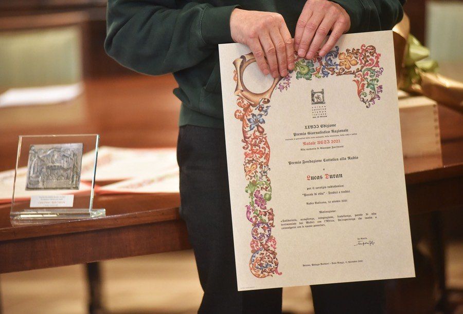 Una persona ha in mano un certificato con un bordo floreale