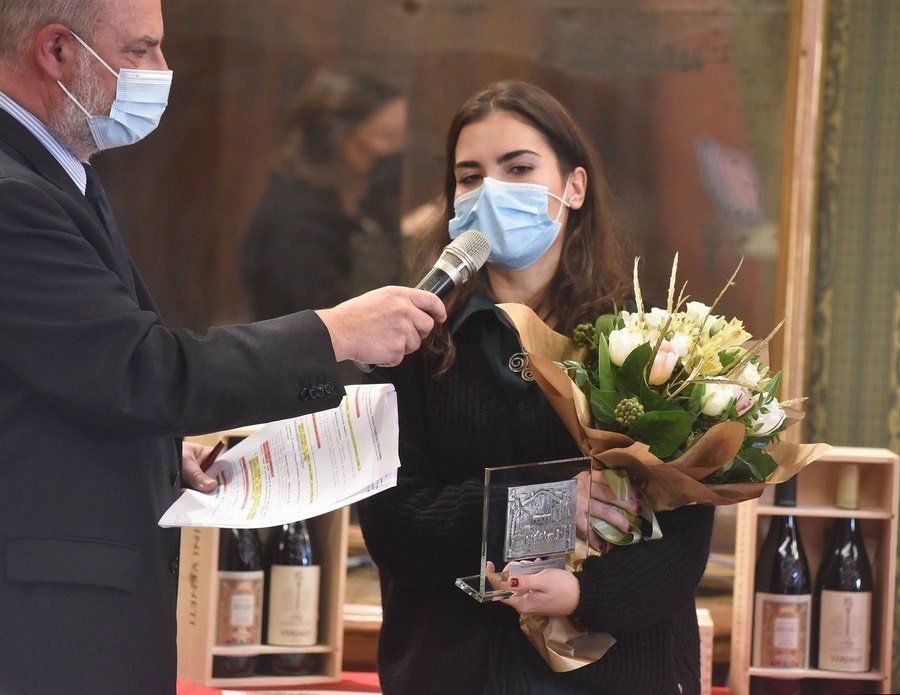 Una donna che indossa una maschera viene intervistata da un uomo