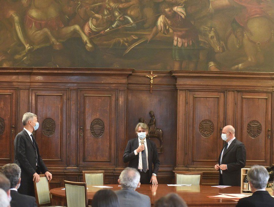 Un gruppo di uomini che indossano maschere per il viso sono in piedi attorno a un tavolo in una stanza.