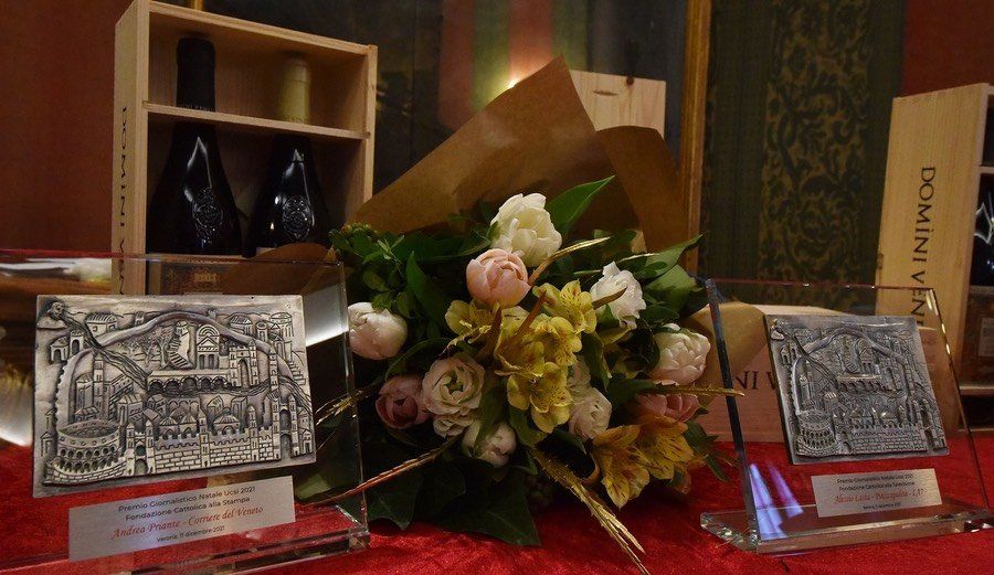 Un mazzo di fiori è posto su un tavolo accanto a due trofei