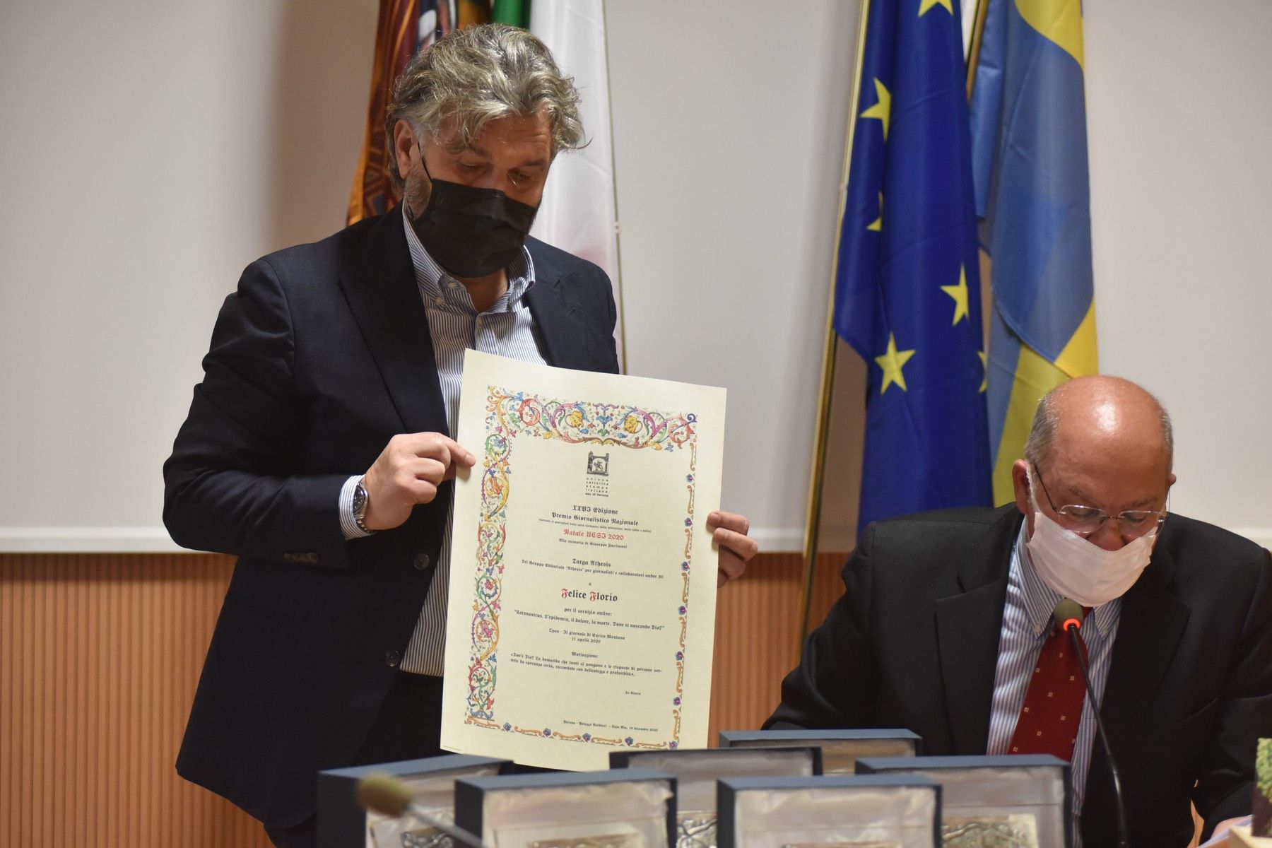 Un uomo in giacca e cravatta è in possesso di un certificato.