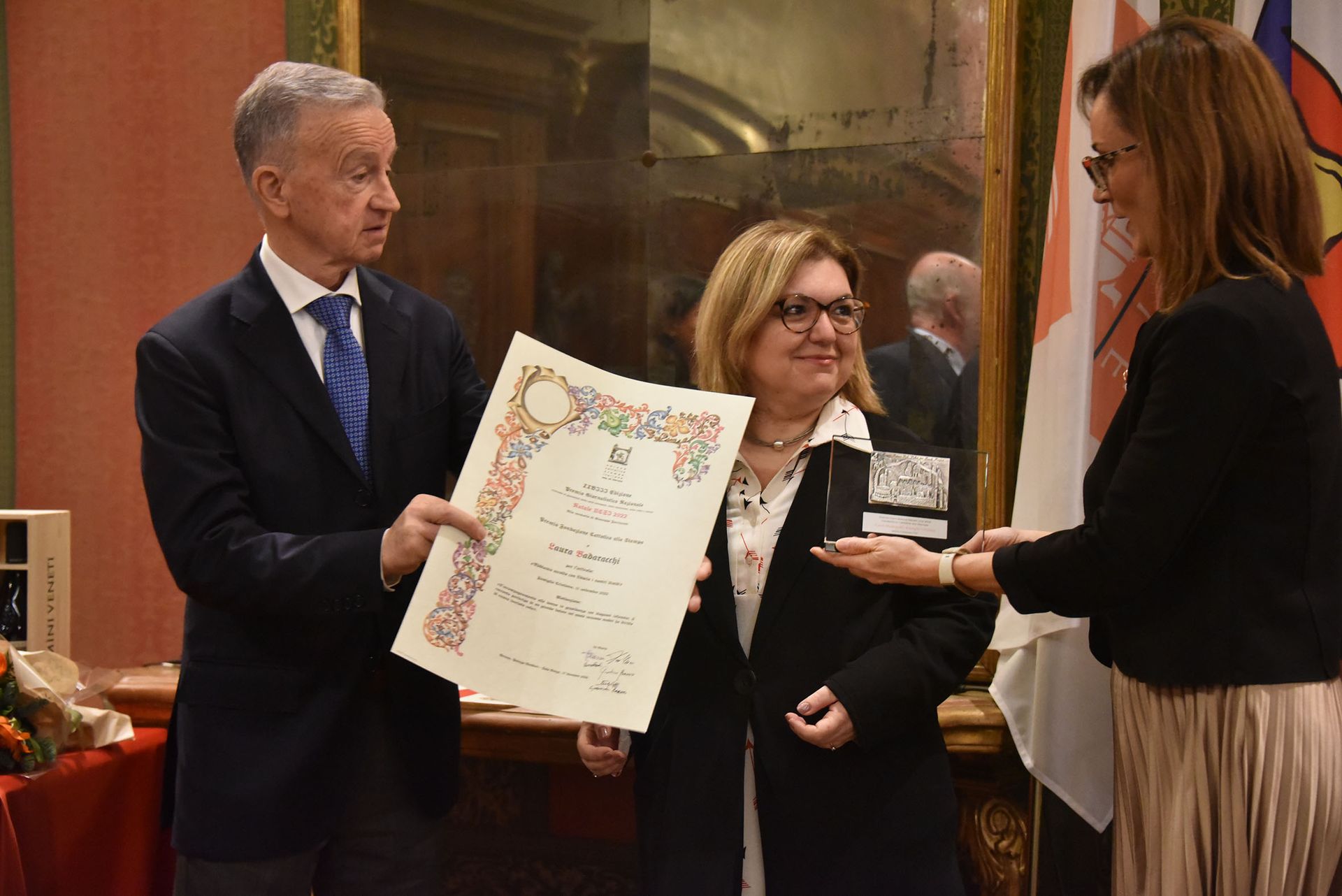 Un uomo in giacca e cravatta sta consegnando un certificato a una donna.