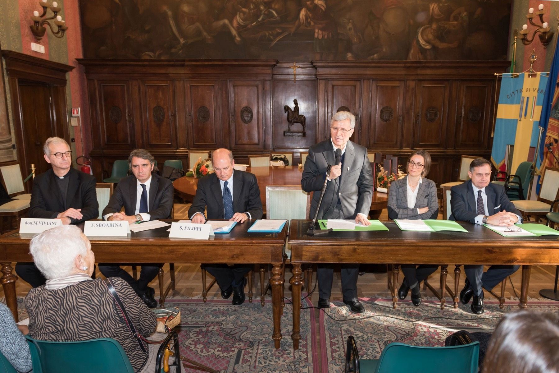 Un gruppo di persone è seduto ai tavoli in una stanza.