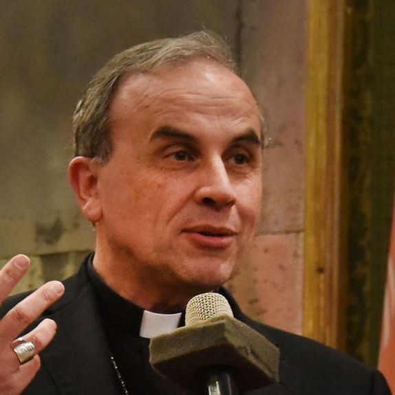 Un uomo vestito di nero parla al microfono
