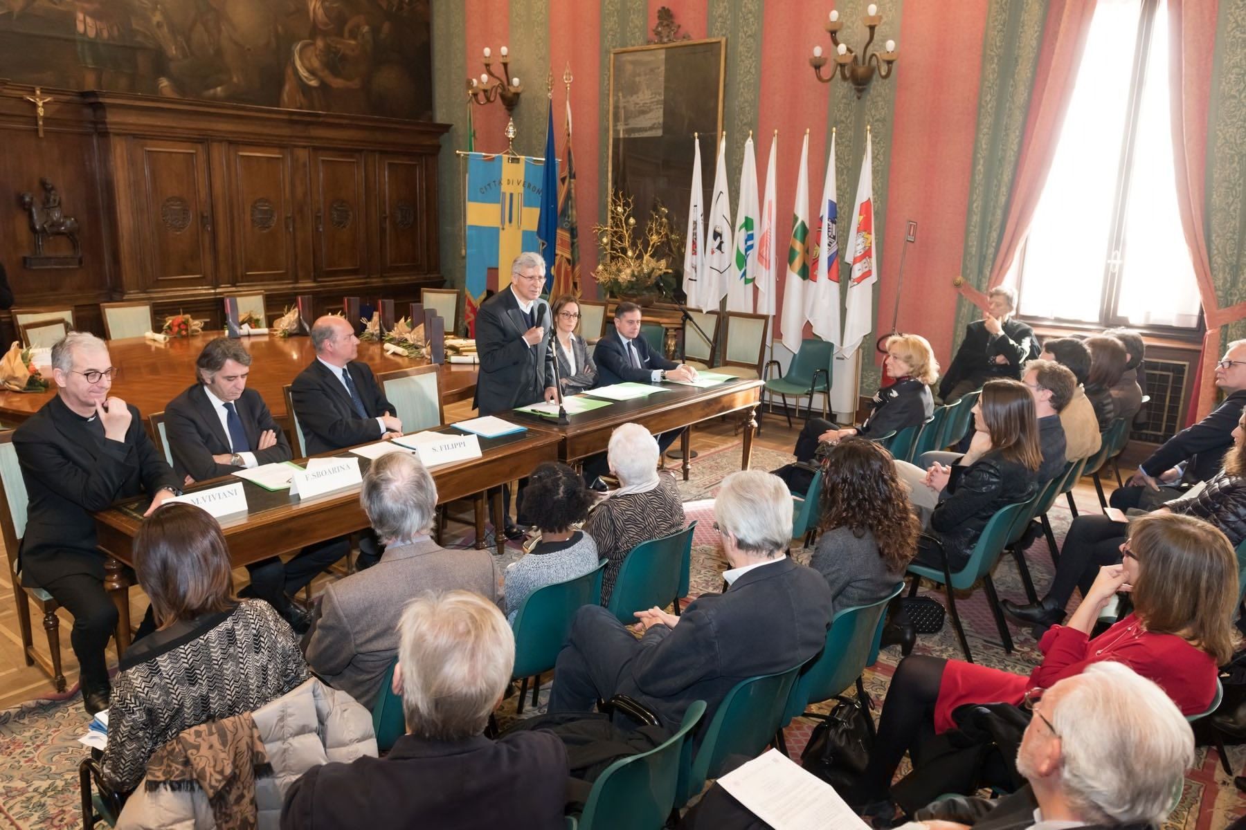 Un gruppo di persone è seduto attorno a un tavolo in una stanza.