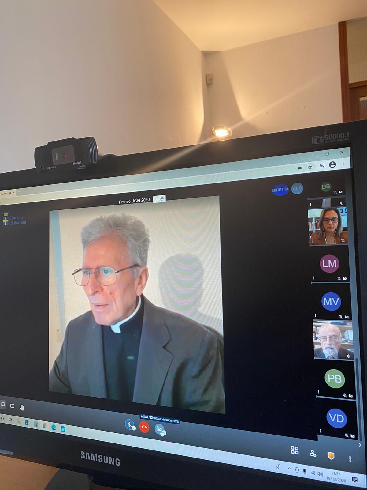 Un uomo in giacca e cravatta è seduto davanti allo schermo di un computer.