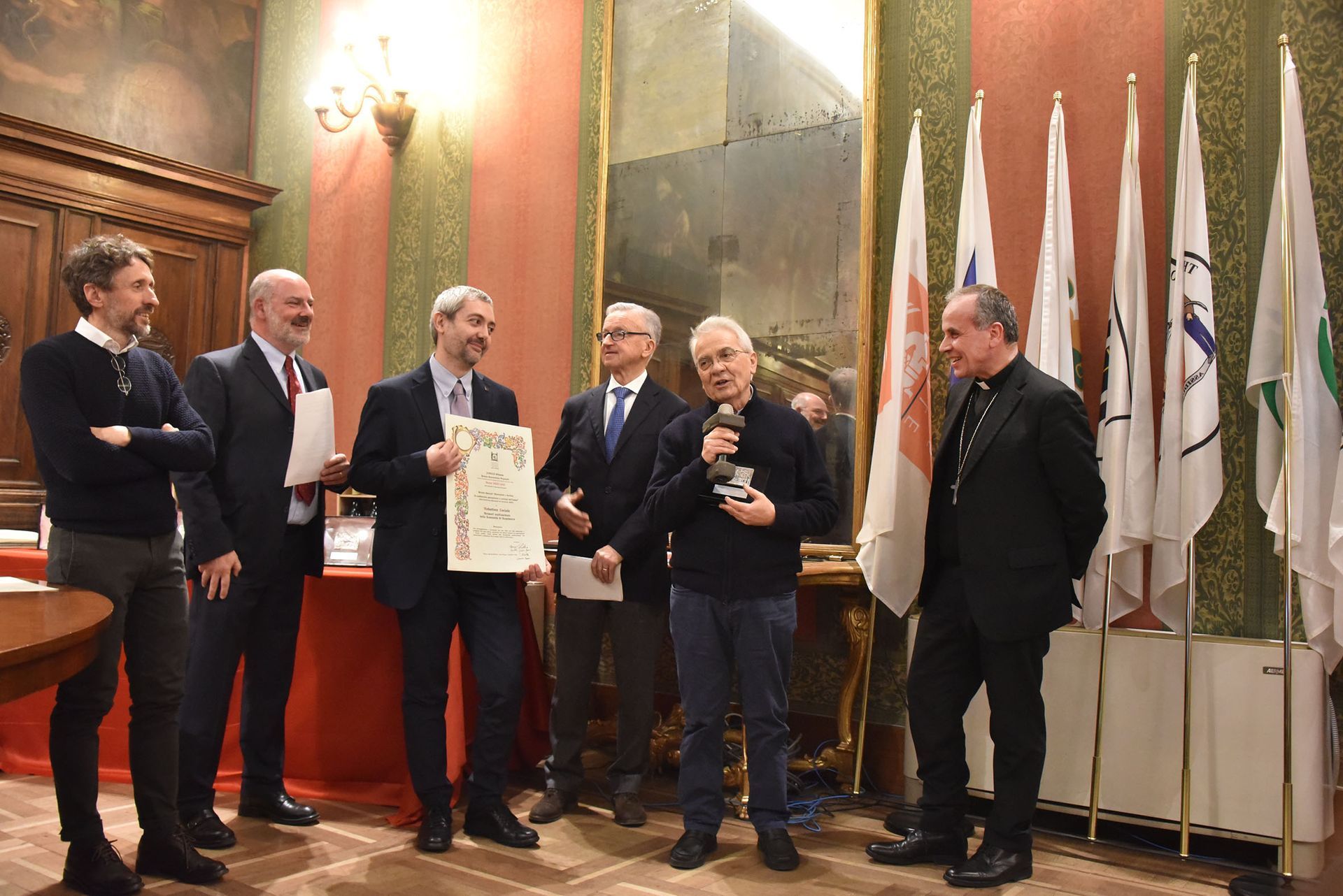 Un gruppo di uomini è in una stanza con delle bandiere.