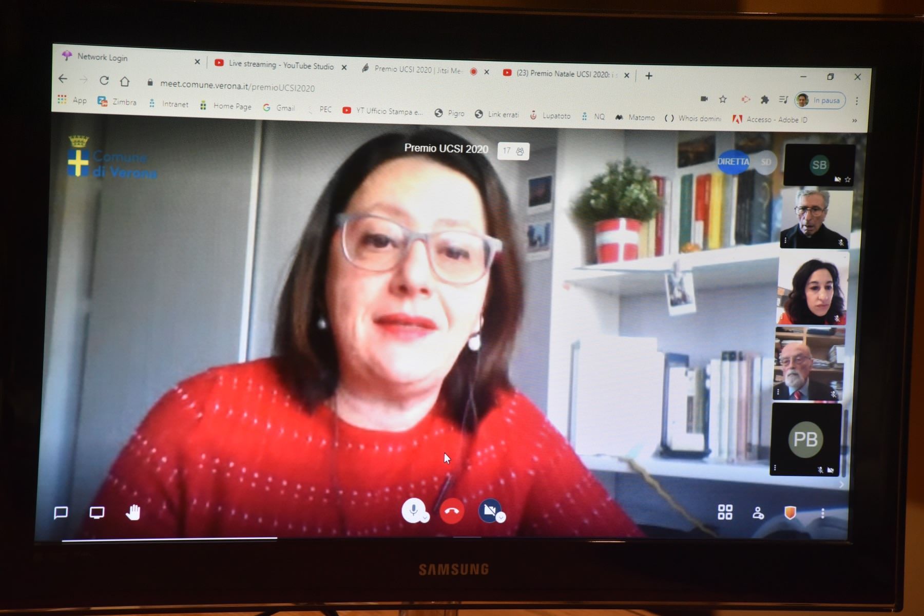 Una donna con un maglione rosso è impegnata in una videochiamata