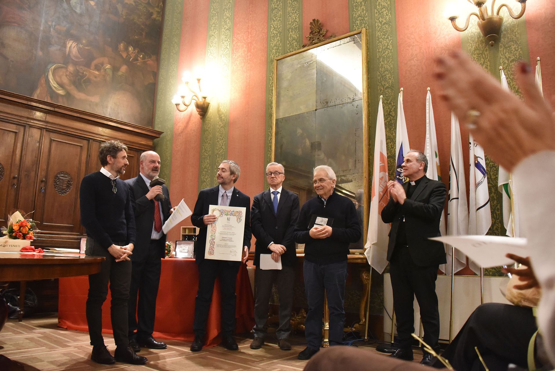 Un gruppo di uomini è in una stanza con delle bandiere.