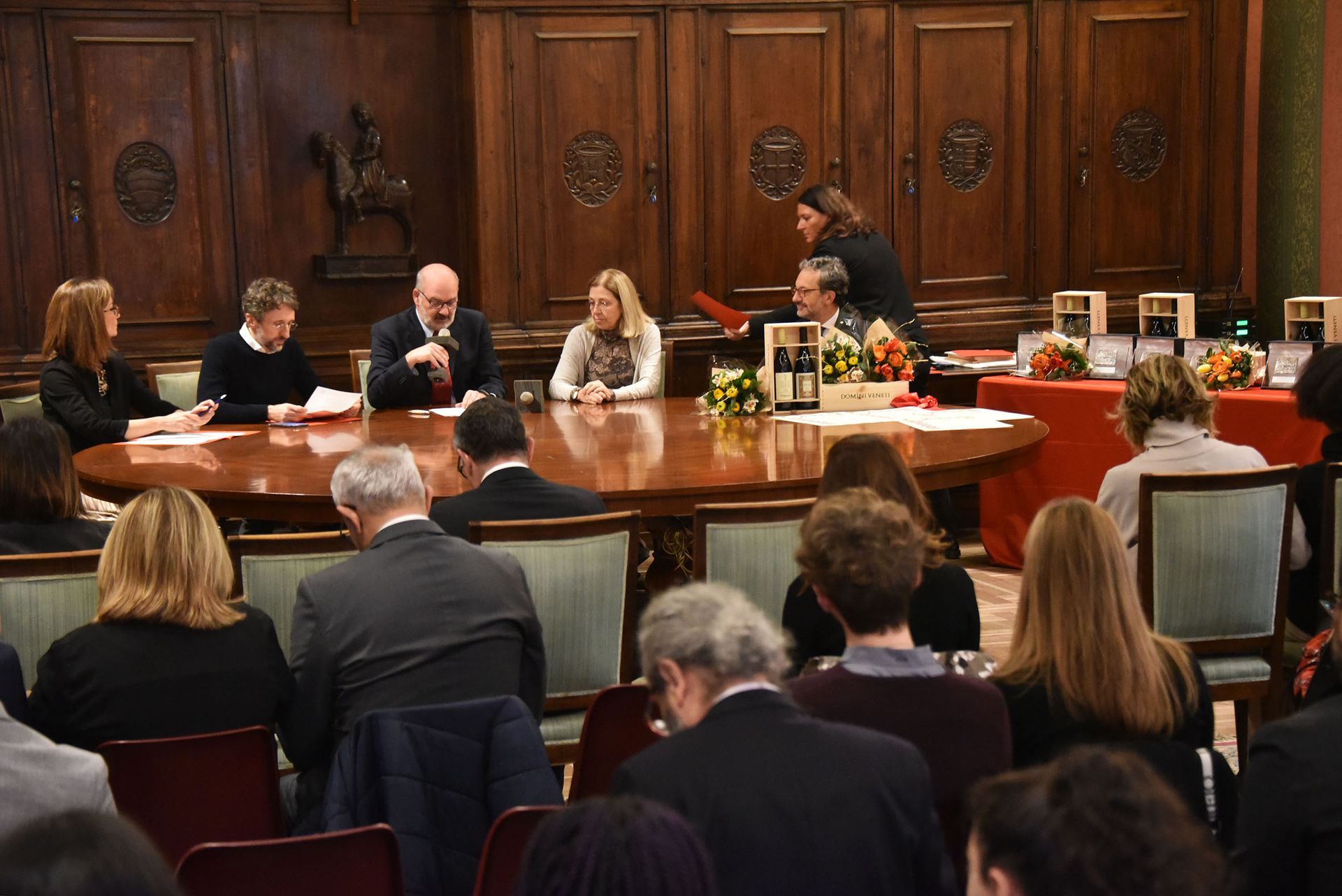 Un gruppo di persone è seduto attorno a un tavolo in una stanza.