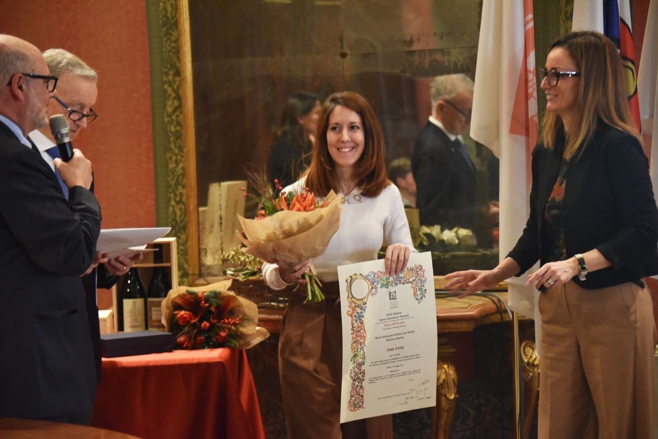 Un uomo regala a una donna un mazzo di fiori e un certificato.
