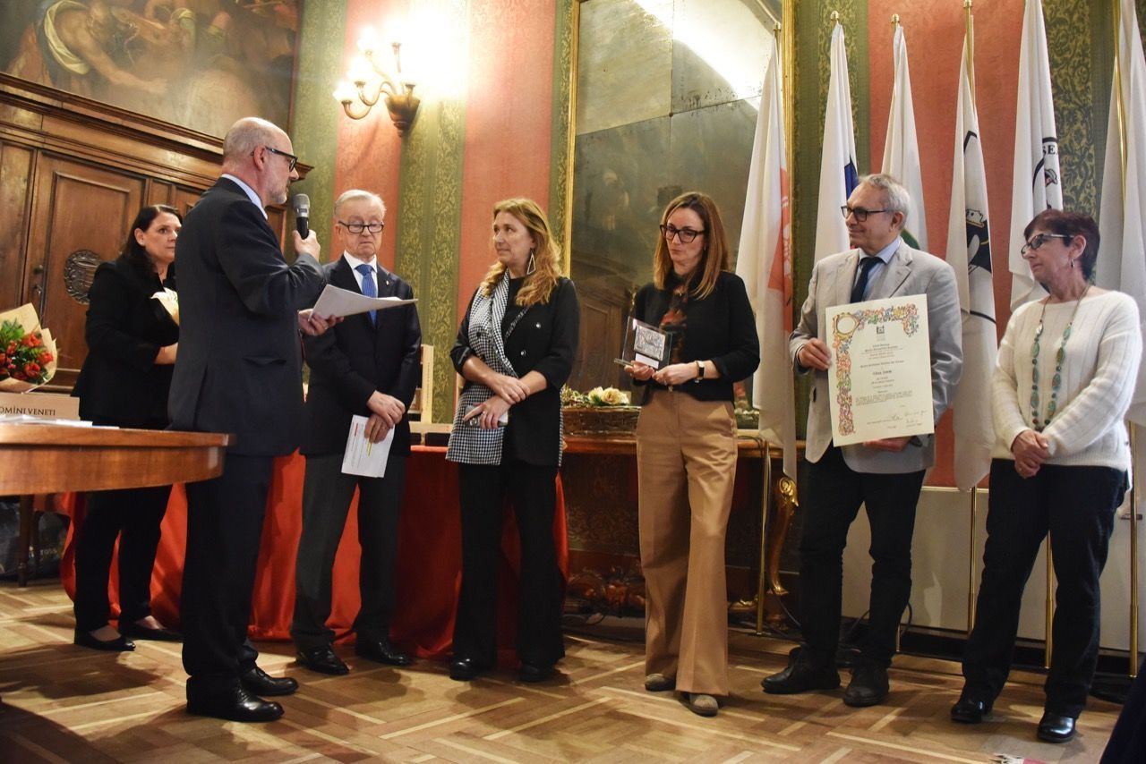Un gruppo di persone è in una stanza con le bandiere.