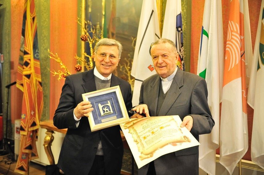 Due uomini sono in piedi uno accanto all'altro con in mano un certificato
