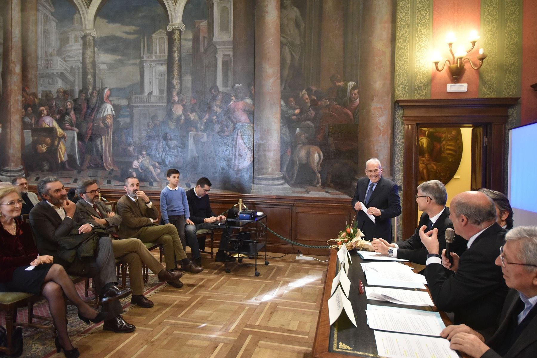 Un gruppo di persone è seduto attorno a un tavolo in una stanza.
