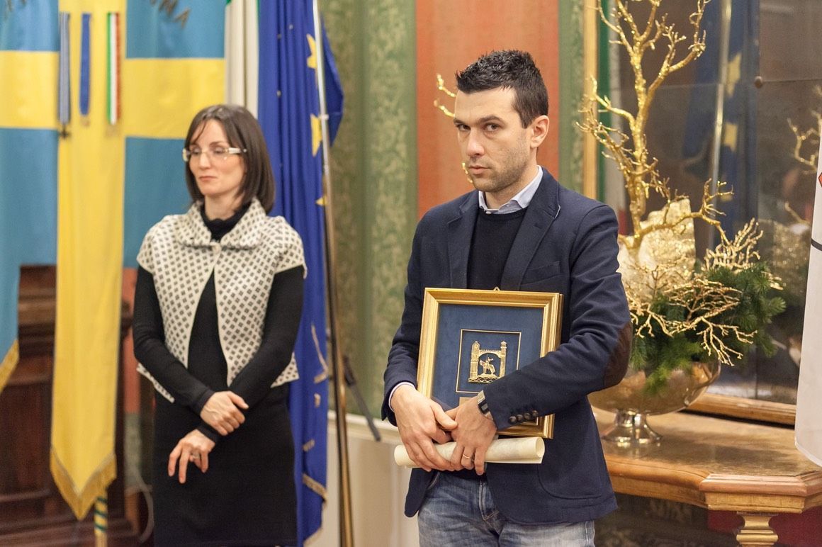 Un uomo e una donna sono in piedi uno accanto all'altro con in mano una foto incorniciata.