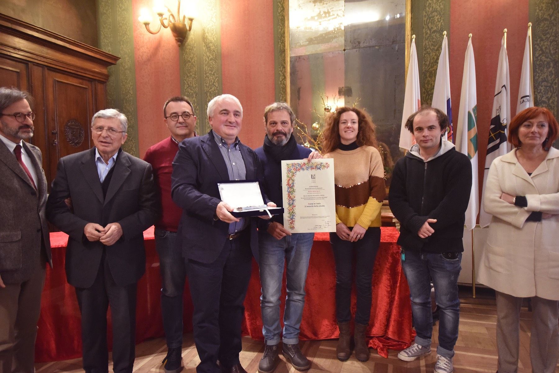 Un gruppo di persone è in una stanza con in mano un certificato.
