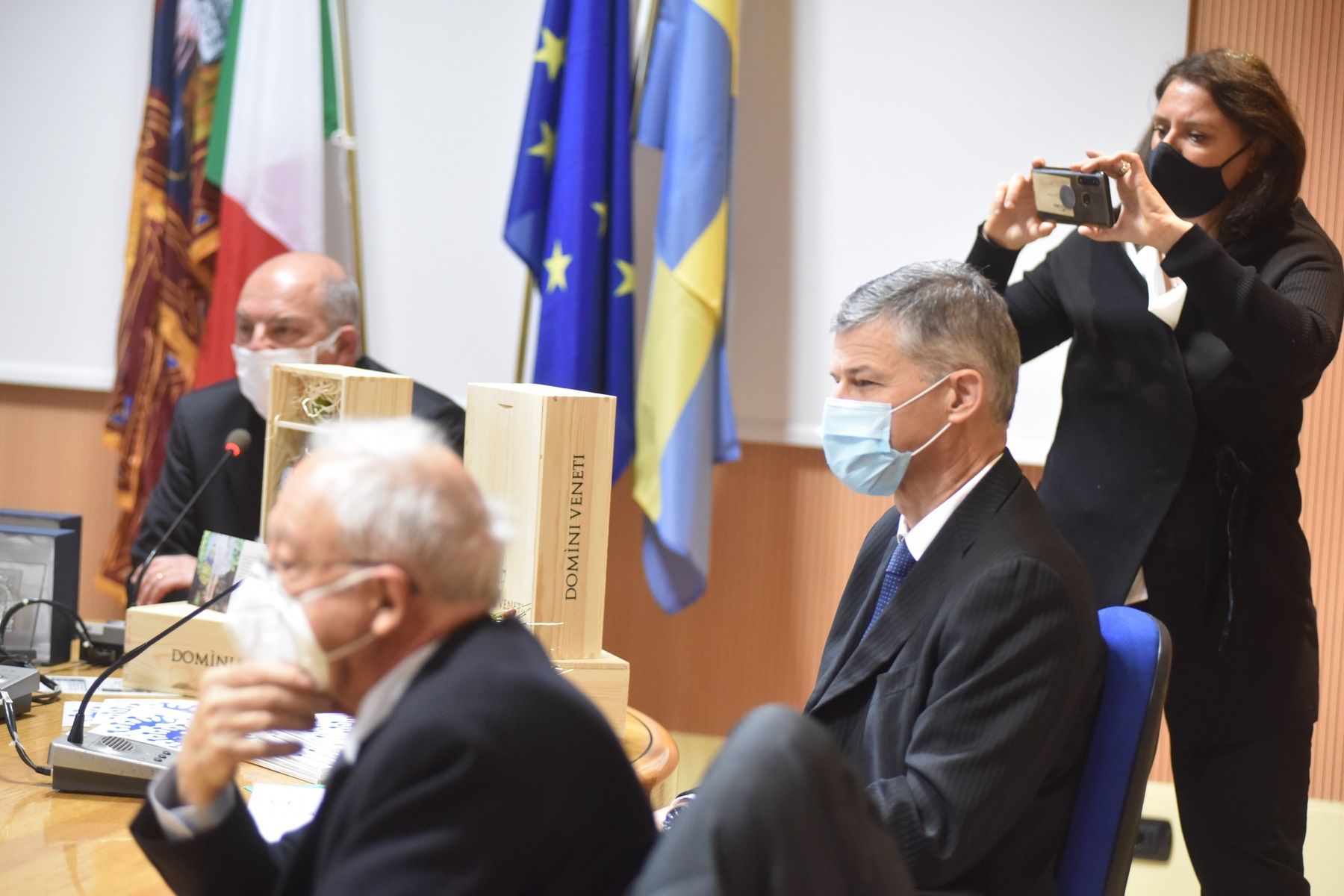 Una donna sta scattando una foto di un uomo che indossa una maschera