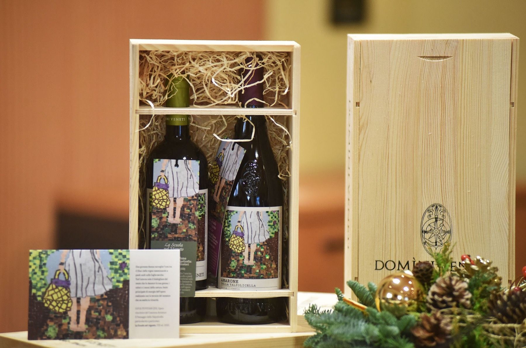 Due bottiglie di vino sono in una scatola di legno su un tavolo.