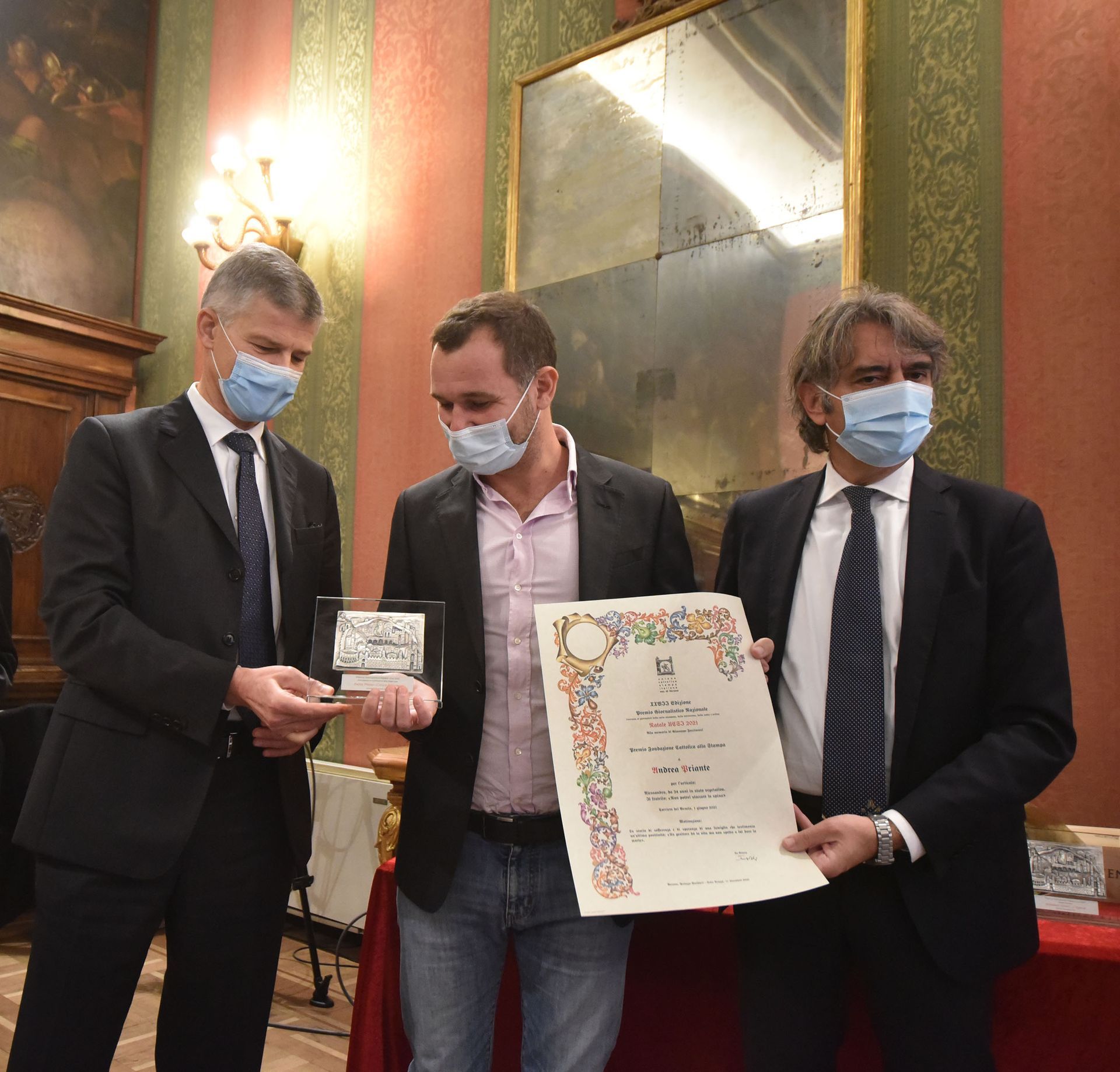 Tre uomini che indossano maschere per il viso hanno in mano un certificato