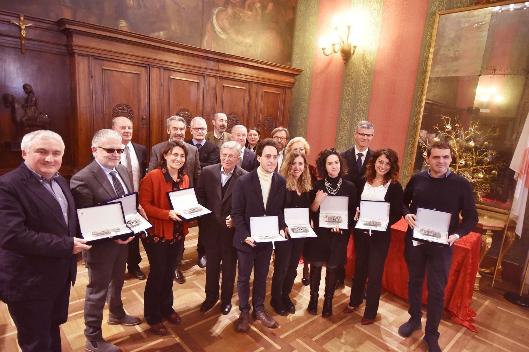 Un gruppo di persone è in una stanza con in mano dei premi.