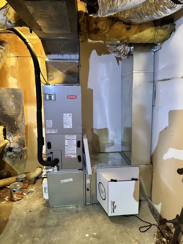 Basement utility room with HVAC units, ductwork, and exposed insulation along unfinished walls