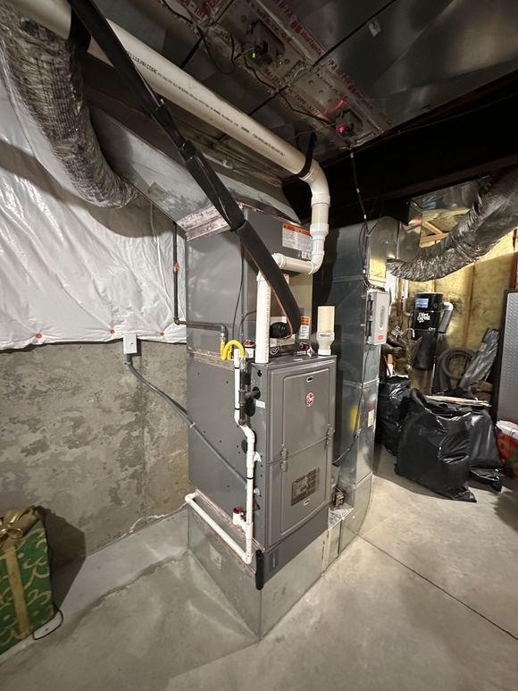 Basement utility room with furnace, exposed ducts, and insulated walls