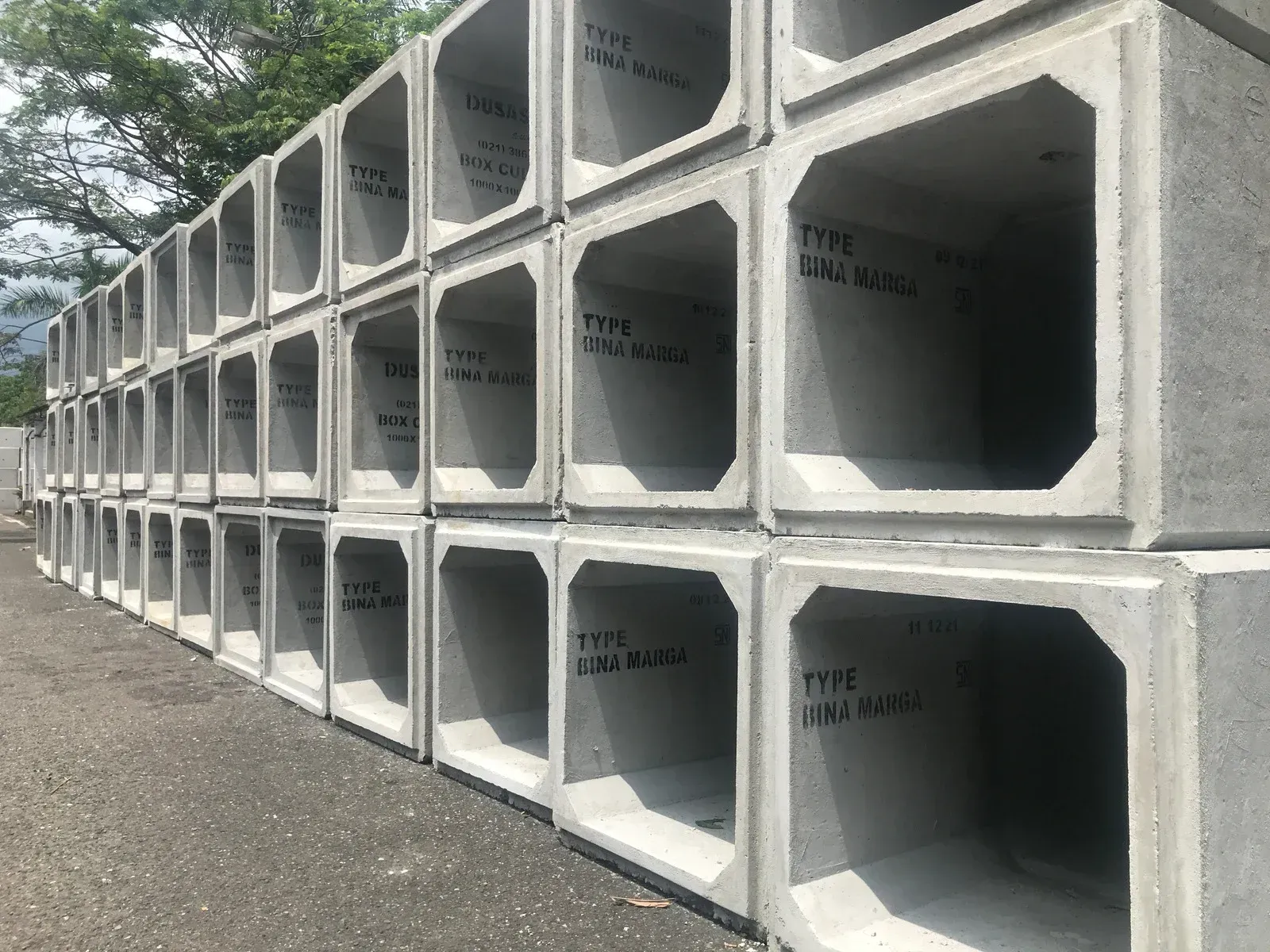 Stacked gray concrete culverts lined along a road