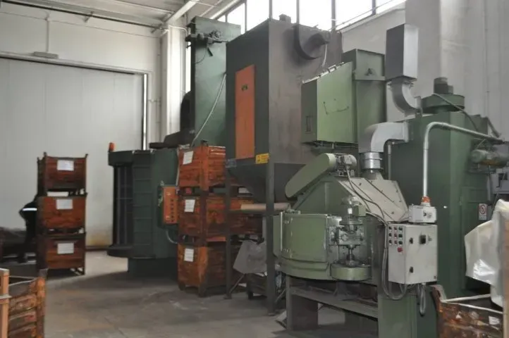 Officina industriale con grandi macchinari verdi e arancioni disposti in un locale di fabbrica