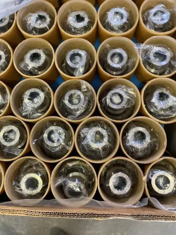 Scatola di cartone piena di file di piccoli oggetti arrotolati, avvolti in plastica trasparente e carta velina.