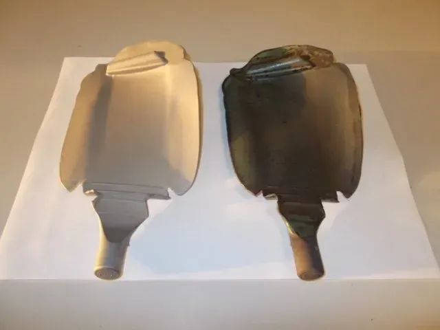 Due borse dell'acqua calda portatili, una color crema e una marrone scuro, una accanto all'altra su una superficie bianca.