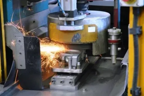 Smerigliatrice industriale con scintille che volano in un'officina di fabbrica
