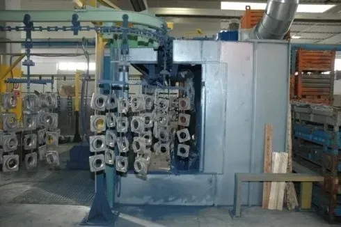 Macchinario industriale con bobine e tubi metallici impilati in un'officina di fabbrica