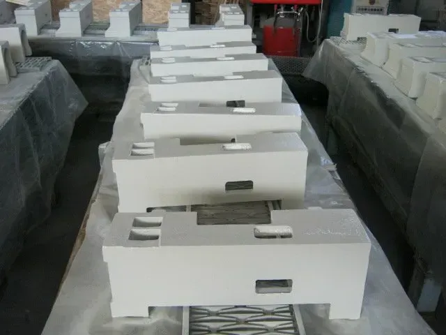 File di contenitori di plastica rettangolari bianchi in un magazzino o in un'officina.
