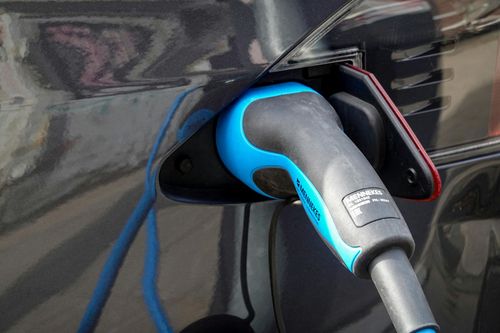 Electric car charging plug inserted into a vehicle’s charging port.