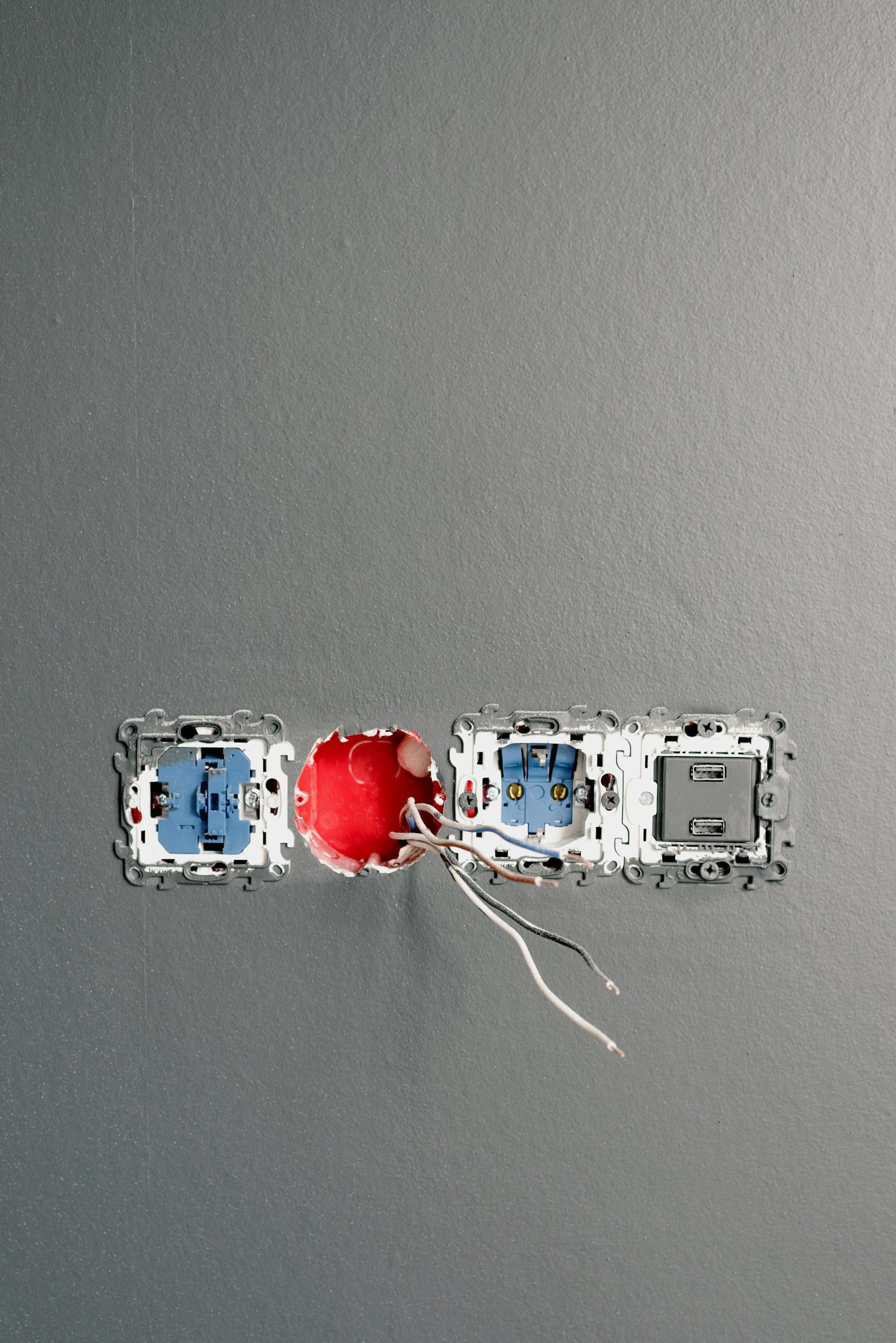Overhead view of a small red toy car between two white-blue toy vehicles on a gray surface