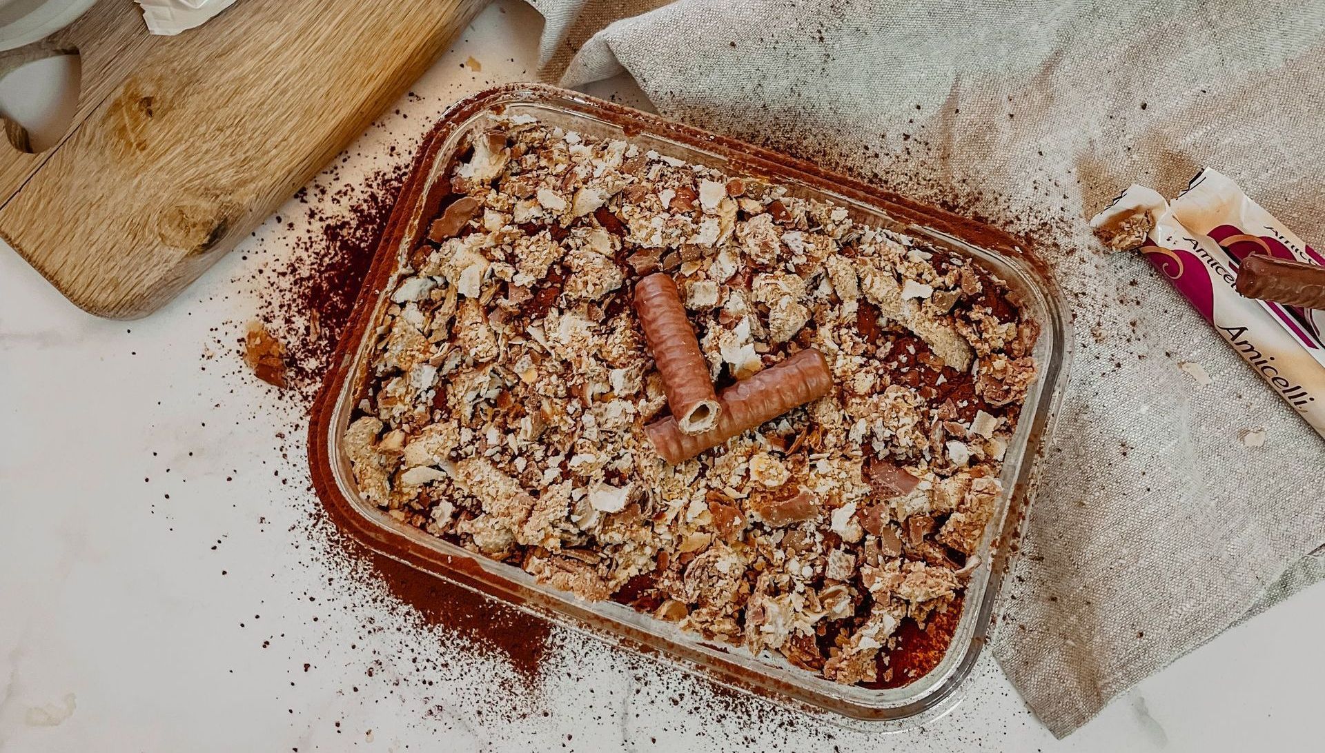 A casserole dish filled with food and a spatula on a table.