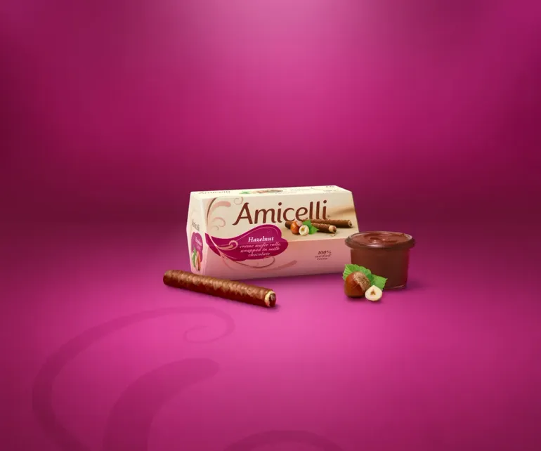 Amicelli box, with chocolate wafers on a pink background, with a glass of hazelnutcreme