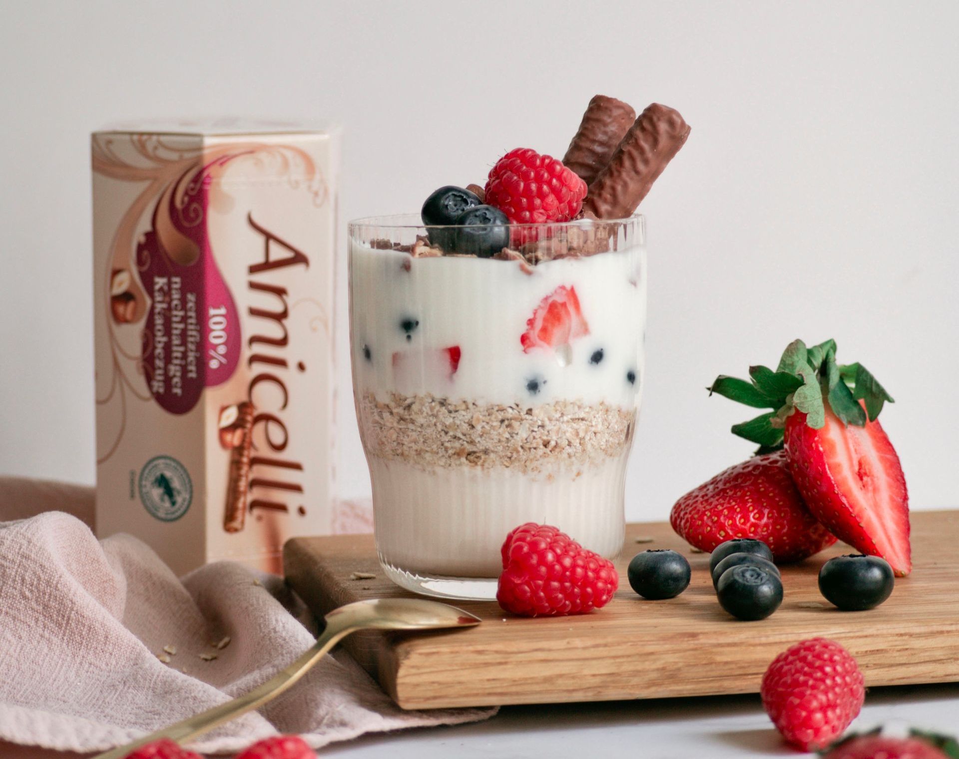 A glass of yogurt with raspberries and blueberries on top